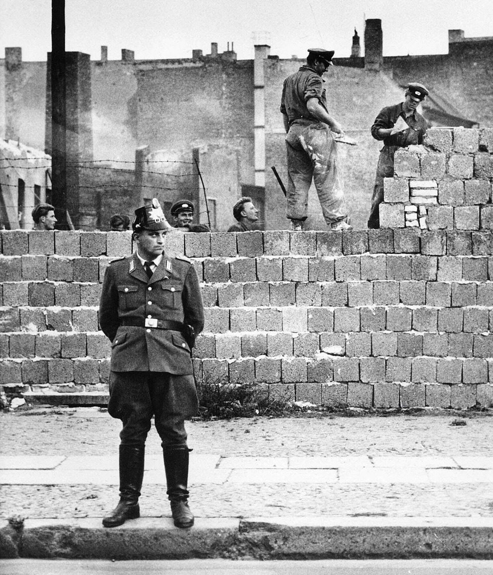 Западноберлинский полицейский охраняет строительство Берлинской стены