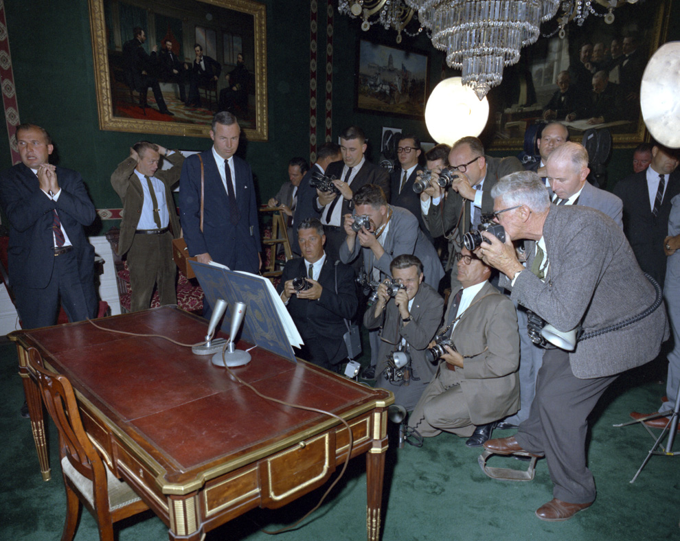 Группа фотографов снимают текст договора об отмене ядерных испытаний, с подписью президента Кеннеди