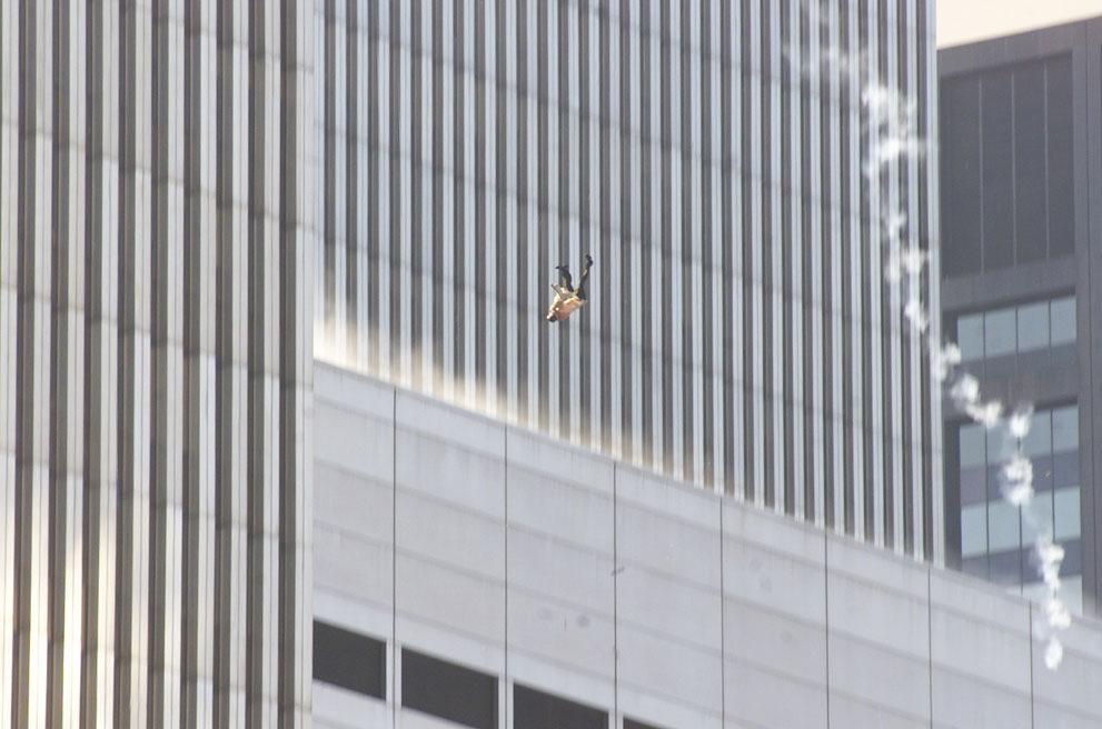 Человек прыгает с верхних этажей горящего Северной башни Мирового Торгового Центра в Нью-Йорке 11 сентября 2001 года. 