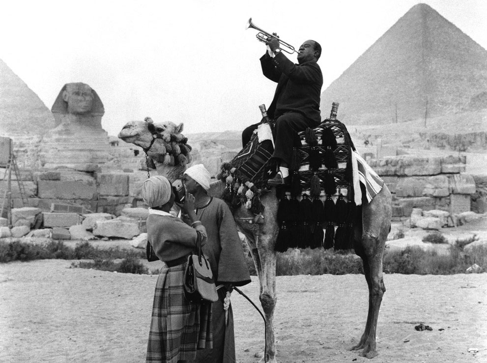 Великий трубач Луи Армстронг играет, сидя на верблюде, возле пирамид