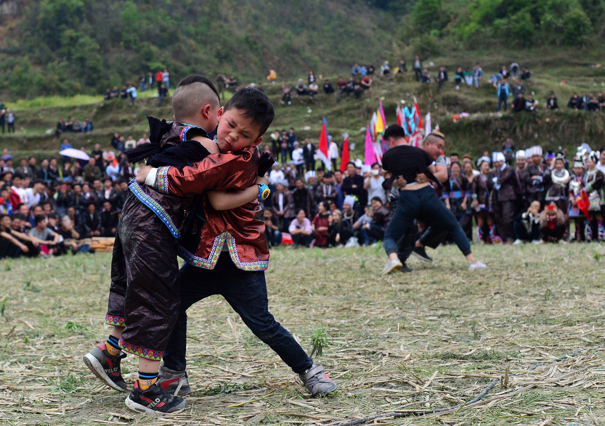 Дети народности дун участвуют в соревнованиях по борьбе, в деревне Кенгдонг, в префектуре Цяньдуннань.