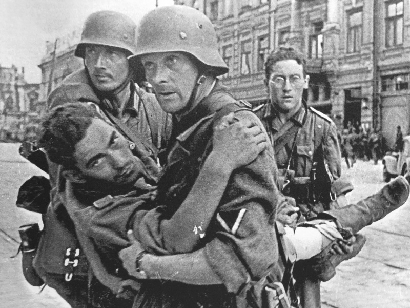 Немецкие солдаты переносят раненого товарища на Буденновском проспекте в Ростове-на-Дону.
