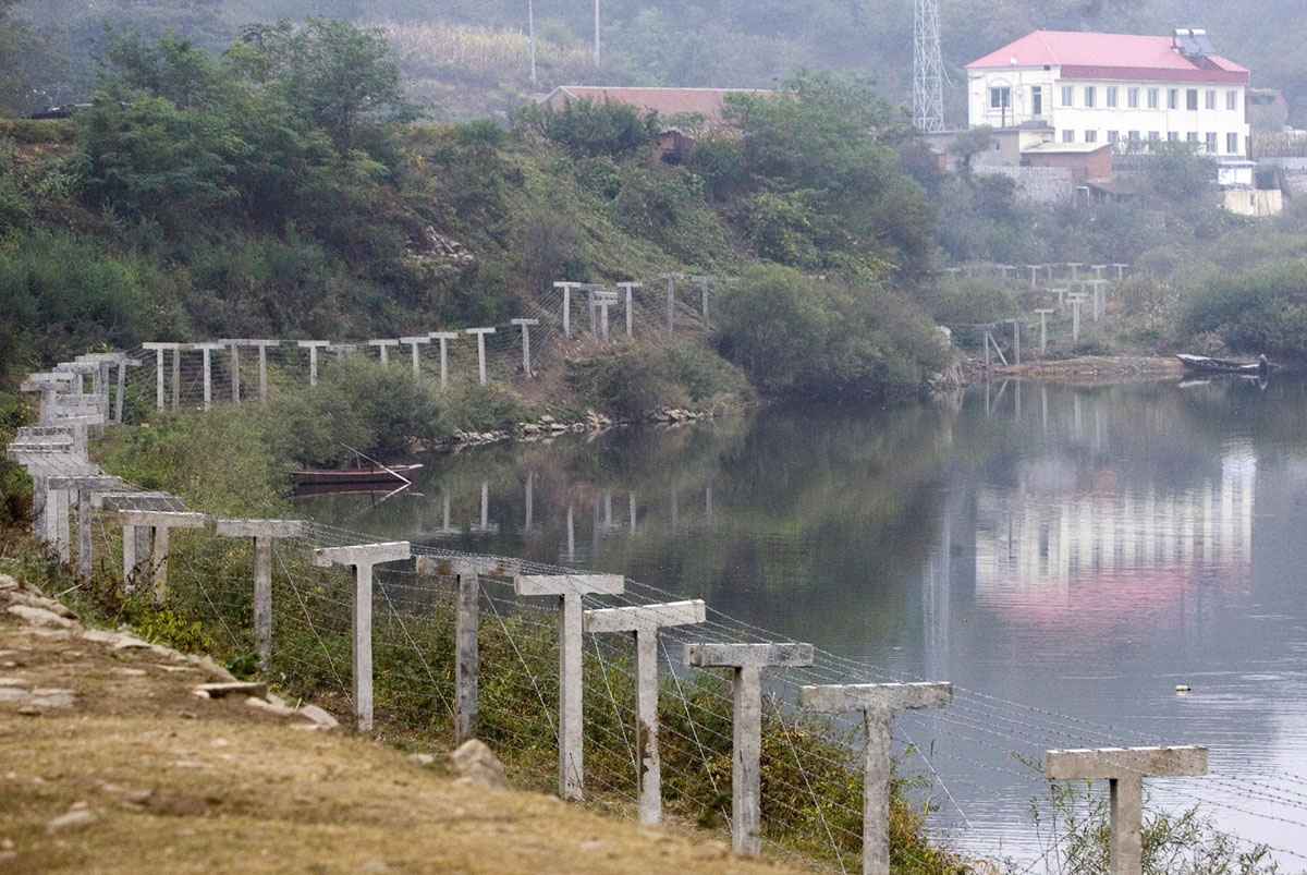 Пограничный забор, отделяющий Северную Корею от города Даньдун (Dandong) на северо-востоке Китая, 15 октября 2006 года.