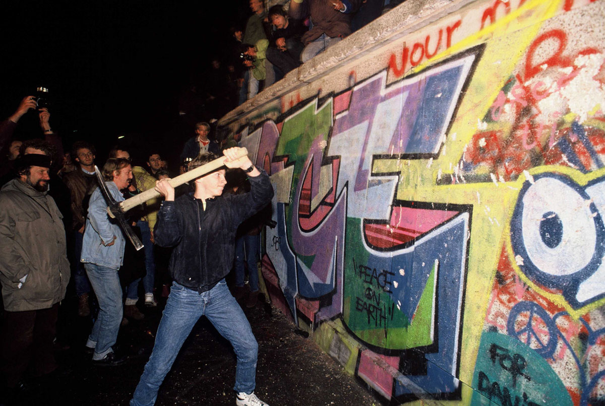 Ночью 9 ноября 1989 года мужчина пытается разбить Берлинскую стену киркой, после того, как быстро распространилась новость о том, что правительство Восточной Германии должно начать выдавать выездные визы всем, кто хотел поехать в Западную Германию. Это заявление было неверно истолковано, люди поняли, что граница теперь открыта, а восточно-германские пограничники не смогли остановить поток людей к стене. В течение нескольких часов люди разбивали участки стены своими ручными инструментами, и эти первые проёмы в стене привели тому, что граница была полностью открыта в течение следующих нескольких дней.