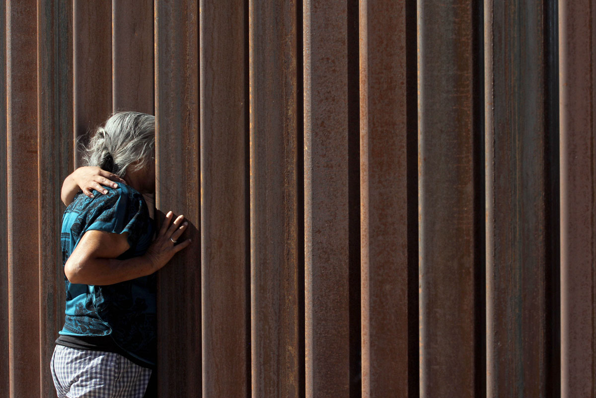Две женщины обнимают друг друга через стену во время проведения демонстрации активистов «против стены» в Соединенных Штатах, проходящей перед стеной, которая разделяет Сьюдад-Хуарес (Ciudad Juarez), Мексика, от Санленд Парк (Sunland Park), Нью-Мексико, 23 октября 2017 года.